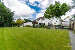 a house with a large lawn in front of it at Luxe Home with Hot Tub, Cinema, Games Room & Sauna in Buckinghamshire