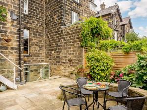 um pátio com uma mesa e cadeiras e um edifício de tijolos em 2 bed in Ilkley 89554 em Ilkley