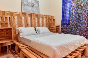 a bedroom with a bed made out of wood at Maasai House - Arusha in Sokon