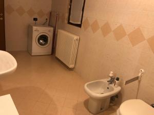 bagno con lavandino e servizi igienici e lavatrice. di La casetta della felicità, comodità tra Milano e Bergamo a Capriate San Gervasio