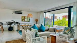 ein Wohnzimmer mit einem Sofa und einem Tisch in der Unterkunft Villa familiale avec piscine in Tamarin