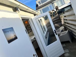 una puerta blanca con una foto de una playa en Huisje bij Zee (gratis parkeren) en Noordwijk aan Zee