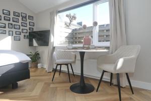 een kamer met een tafel, 2 stoelen en een raam bij Huisje bij Zee (gratis parkeren) in Noordwijk aan Zee