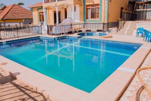 a swimming pool with blue water in front of a house at Kigali Bright boutique in Kigali