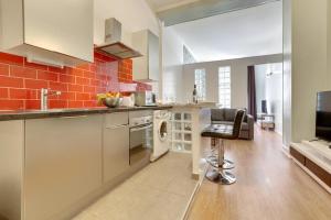 cocina con fregadero y taburete en 253 Suite Martinez - Superb apartment in Paris, en París