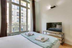a bedroom with a bed and a large window at 253 Suite Martinez - Superb apartment in Paris in Paris