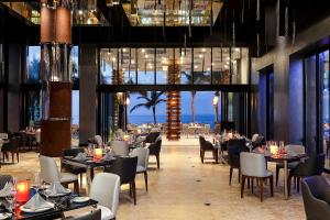 a restaurant with tables and chairs and a view of the ocean at Residential Retreat 3 Bedroom Suite Ocean Front Garza Blanca Los Cabos Resort & Spa in Cabo San Lucas