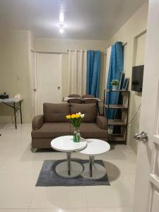 a living room with a couch and a table with flowers on it at Pagadian Staycation in Camella 1 in Pagadian