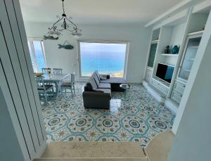 a living room with a couch and a view of the ocean at Bella Tropea Suite in Tropea