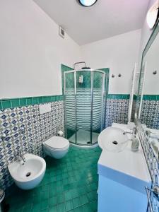 a bathroom with two sinks and a shower and a toilet at Bella Tropea Suite in Tropea