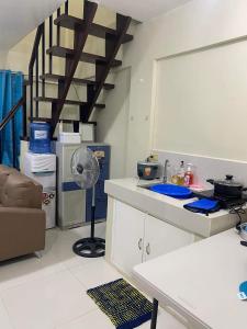 a kitchen with a table and a fan in a room at Pagadian Staycation in Camella 1 in Pagadian