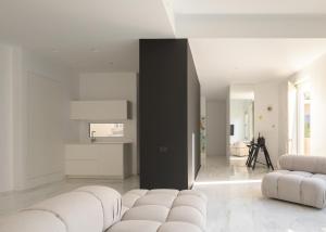 a living room with white furniture and a black wall at TWO VAULTS, Rethymno old town in Rethymno Town +37 photos