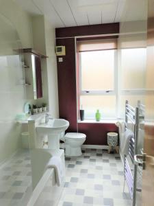 a bathroom with a toilet and a sink and a window at City Centre 2 bedroom apt, close to M8 & Tourist Attractions in Glasgow