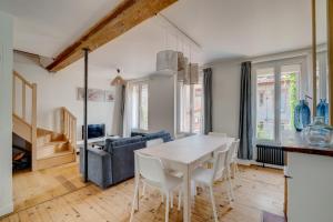 a kitchen and living room with a white table and chairs at Estrela by Yumē in Toulouse