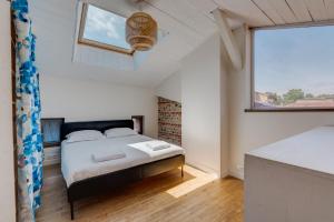a bedroom with a bed and a window at Estrela by Yumē in Toulouse