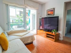 uma sala de estar com uma grande televisão de ecrã plano em Gala Apartment by Hello Homes Sitges em Sitges