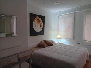 een slaapkamer met een bed, een bureau en een raam bij Apartment near Plaza Ayuntamiento in the historic center of Valencia in Valencia