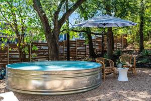 a hot tub with an umbrella and a table and chairs at Urban Cowboy Villas - Heart of 704 in Austin