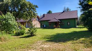 uma casa verde com um quintal em frente em Tajemniczy Ogród 
