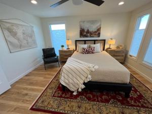 een slaapkamer met een bed, een stoel en ramen bij City View Foothills Home in Boise