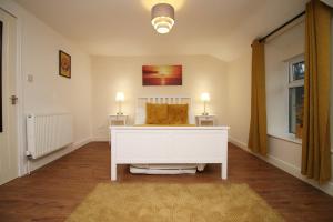 a living room with a white dresser and two lamps at Llareggub by StayStaycations in Port Talbot