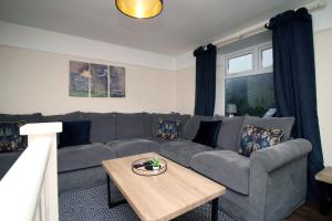 a living room with a couch and a table at Llareggub by StayStaycations in Port Talbot