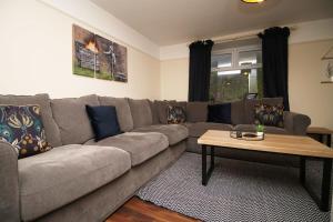 a living room with a couch and a coffee table at Llareggub by StayStaycations in Port Talbot