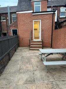a bench sitting in front of a brick building at Ecclesall Suites in Nether Edge