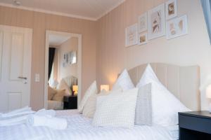 a bedroom with a white bed with white pillows at Dein Ruhepol an der Nordseeküste mit Sauna in Cappel-Neufeld