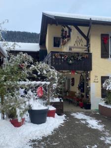 una casa con árboles delante de ella en la nieve en Gite de la Robella, en Buttes