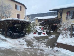 a car parked in front of a house in the snow at Gite de la Robella in Buttes