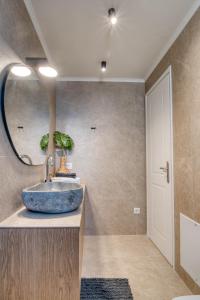 a bathroom with a sink and a mirror at Deluxe Seaside Condo for 6 in Kandia