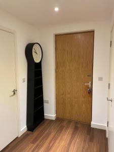 una habitación con un reloj al lado de una puerta en Superior Cambridge 2 Bed Apartment inc King Bed, en Trumpington