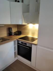 uma cozinha com armários brancos e um forno preto em Sweet home em Lille
