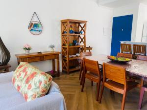 uma sala de estar com uma mesa e uma sala de jantar em Apto com ar-cond e piscina a 100 m praia da Enseada em Ubatuba