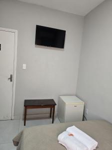 um quarto com uma cama e uma televisão na parede em Hotel Bandeirantes de SJBV em São João da Boa Vista