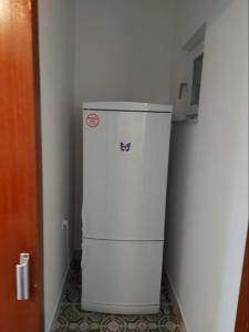 einen weißen Kühlschrank in einer Ecke eines Zimmers in der Unterkunft Apartmani Vesna in Pag