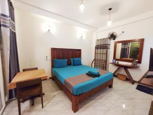 a bedroom with a bed and a table in it at CHEN VILLA - Near Airport in Negombo