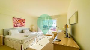 sypialnia z łóżkiem, stołem i oknem w obiekcie YES Vista Marina T1 by HsR Vilamarina w mieście Quarteira