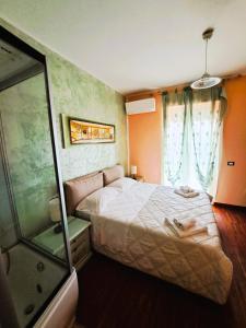 a bedroom with a large bed and a shower at Bosa Guest House in Bosa