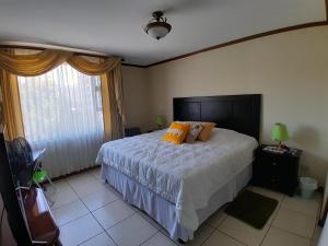 a bedroom with a bed with two pillows on it at Comfortable Apartment with Free Parking in Guatemala