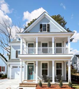 a white house with a porch and a balcony at Three Minute walk to the Beach in Virginia Beach