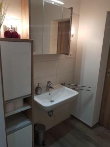 Halverにあるexklusive Ferienwohnungの白い洗面台と鏡のあるバスルーム +36枚の写真