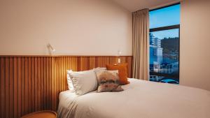 a bedroom with a bed with a large window at Beautiful urban apartment 2 in Nelson