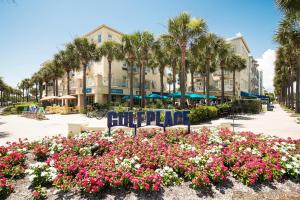 a park with chairs and flowers in front of a building at Lazy Daze at Gulf Place 208 in Santa Rosa Beach