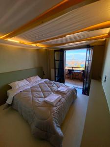 una camera da letto con un grande letto con cuscini sopra di Σκίουρος a Neráïda