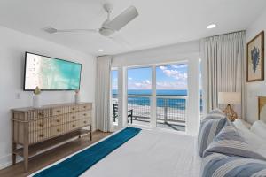 a living room with a tv and a large window at Beachside Bungalow in Destin +43 photos
