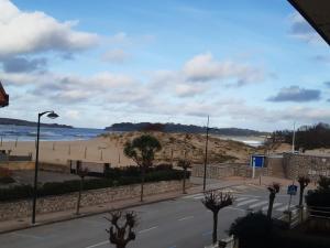 vistas a una playa con carretera y al océano en Casa cerca de la playa en Somo, en Somo