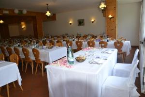 uma sala com mesas e cadeiras com toalhas de mesa brancas em ALBERGO VALLUNGA em Tartano