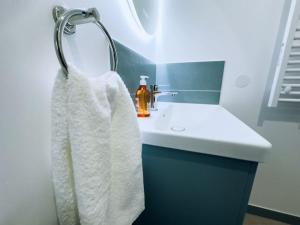 a bathroom with a sink and a white towel at Le Héron - Élégance - Confort moderne - 2RFHomes in Château-Thierry +16 photos